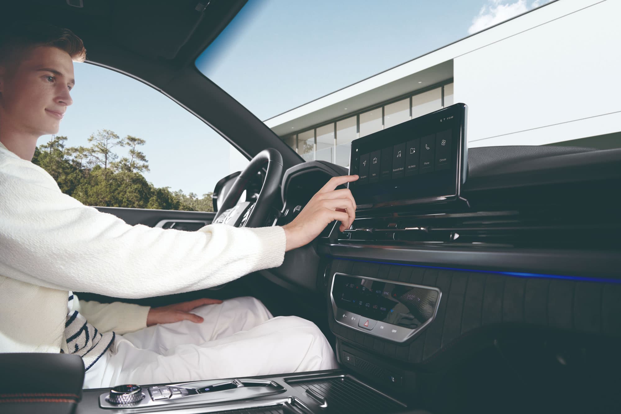 Een mannelijke bestuurder in de Rexton die gebruik maakt van het infotainment en het touchscreen aanraakt